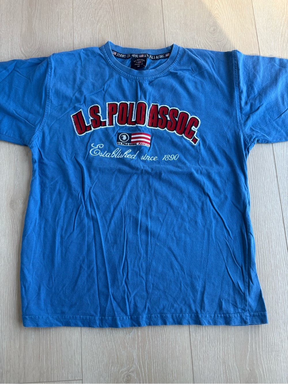 Blue U.S. Polo Assn. cotton t-shirt with red text and flag graphic, size M